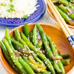 wooden bowl filled with green beans cooked in asian sauce