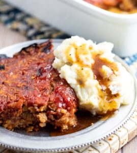 vegan meatloaf with mashed potatoes and gravy on silver plate