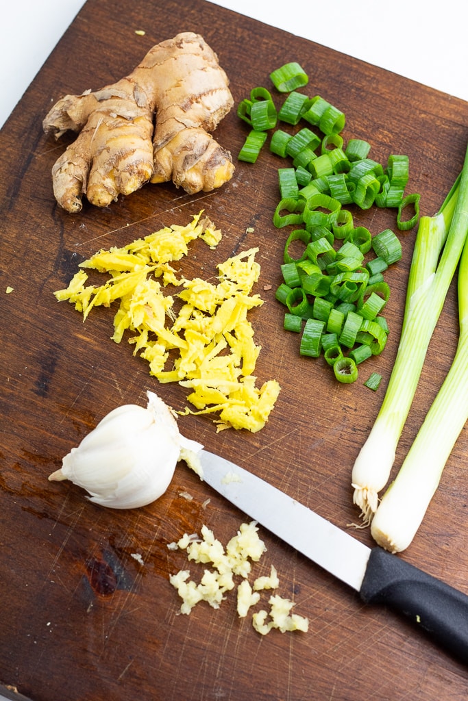 cutting board with ginger, garlic, and green onions