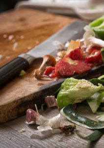 cutting board with vegetable scraps and knife