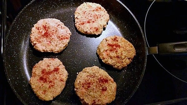 Chickpea burgers cooking in nonstick pan.