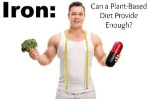 Young man holding a piece of broccoli in one hand and a large diet pill in the other isolated on white background