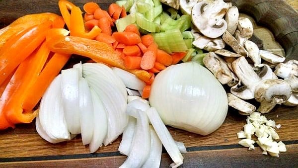 diced onions, peppers, mushrooms, celery on cutting board
