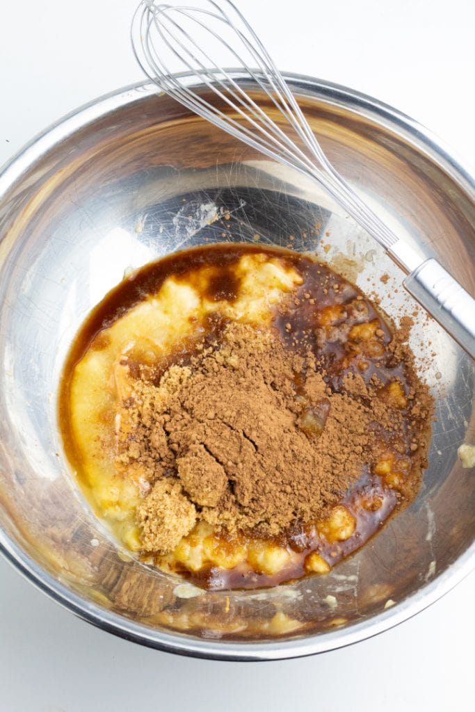 banana, applesauce, cocoa in mixing bowl with whisk