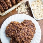 white plate with chocolate oatmeal cookies,scoop with oats in background