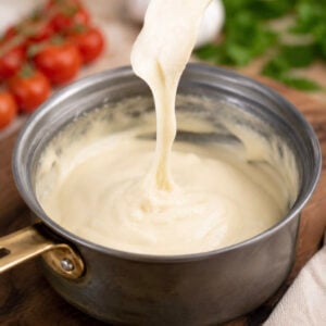 cashew mozzarella vegan cheese stretching in a saucepan on a fork.