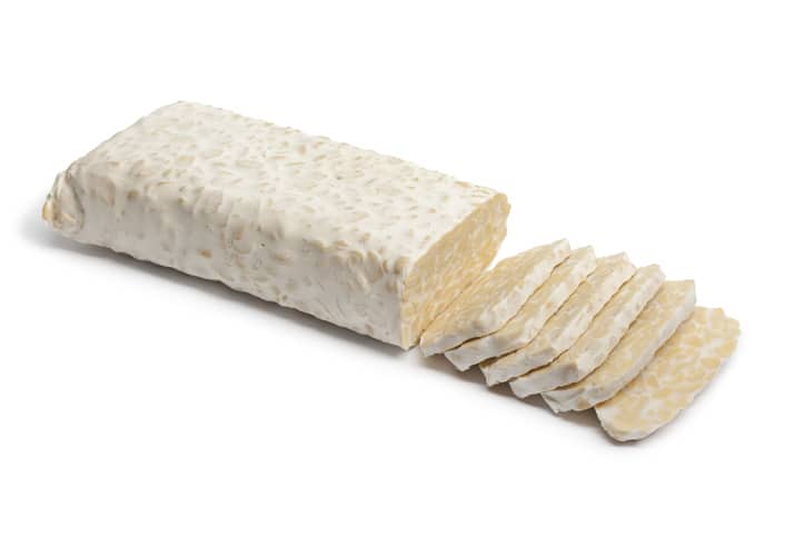 Fresh tempeh with slices on white background ready to cook tempeh bacon