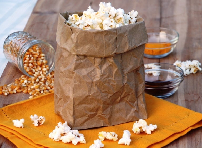 healthy popcorn toppings. brown bag of popcorn.
