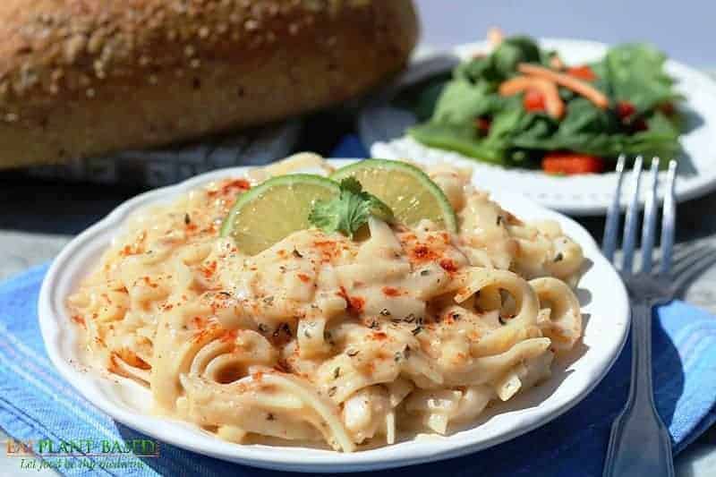 Roasted Garlic butter pasta on white plate with bread in background