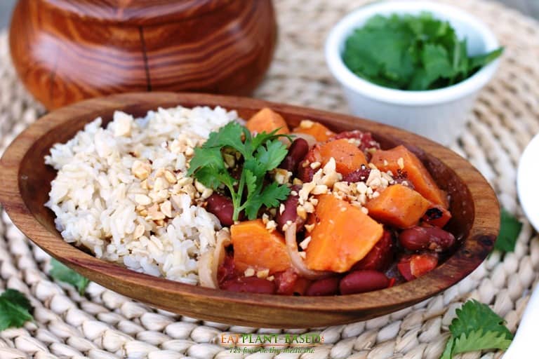 african sweet potato peanut stew with rice in wooden bowl