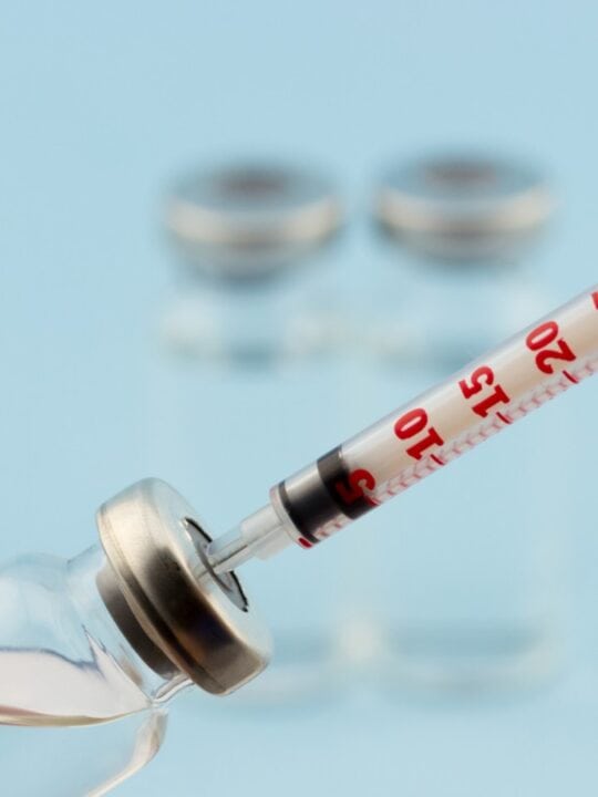 Syringe being filled with insulin in bottle