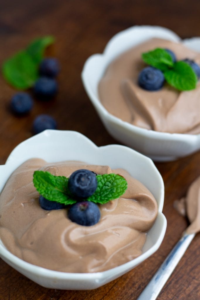 vegan mousse in white bowls and topped with mint leaves and blueberries