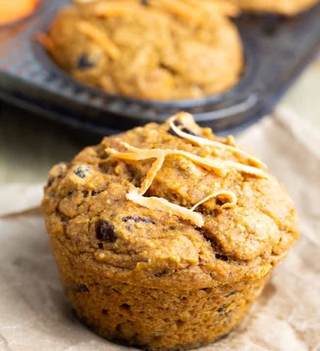 vegan sweet potato muffin on brown paper with muffin pan in background