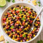 black bean corn salad in a whiite bowl with a fork.