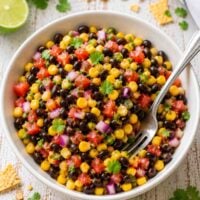black bean corn salad in a whiite bowl with a fork.