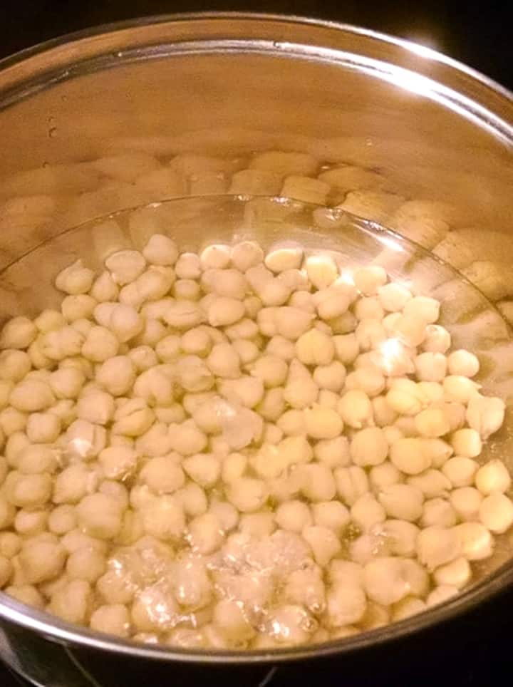 chickpeas soaking in water in stainless pot