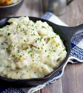 mashed potatoes in cast iron pan on wooden tabletop