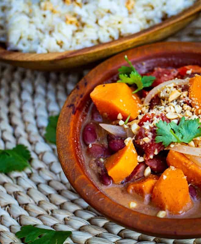 African sweet potato Stew in wooden bowl with rice in background