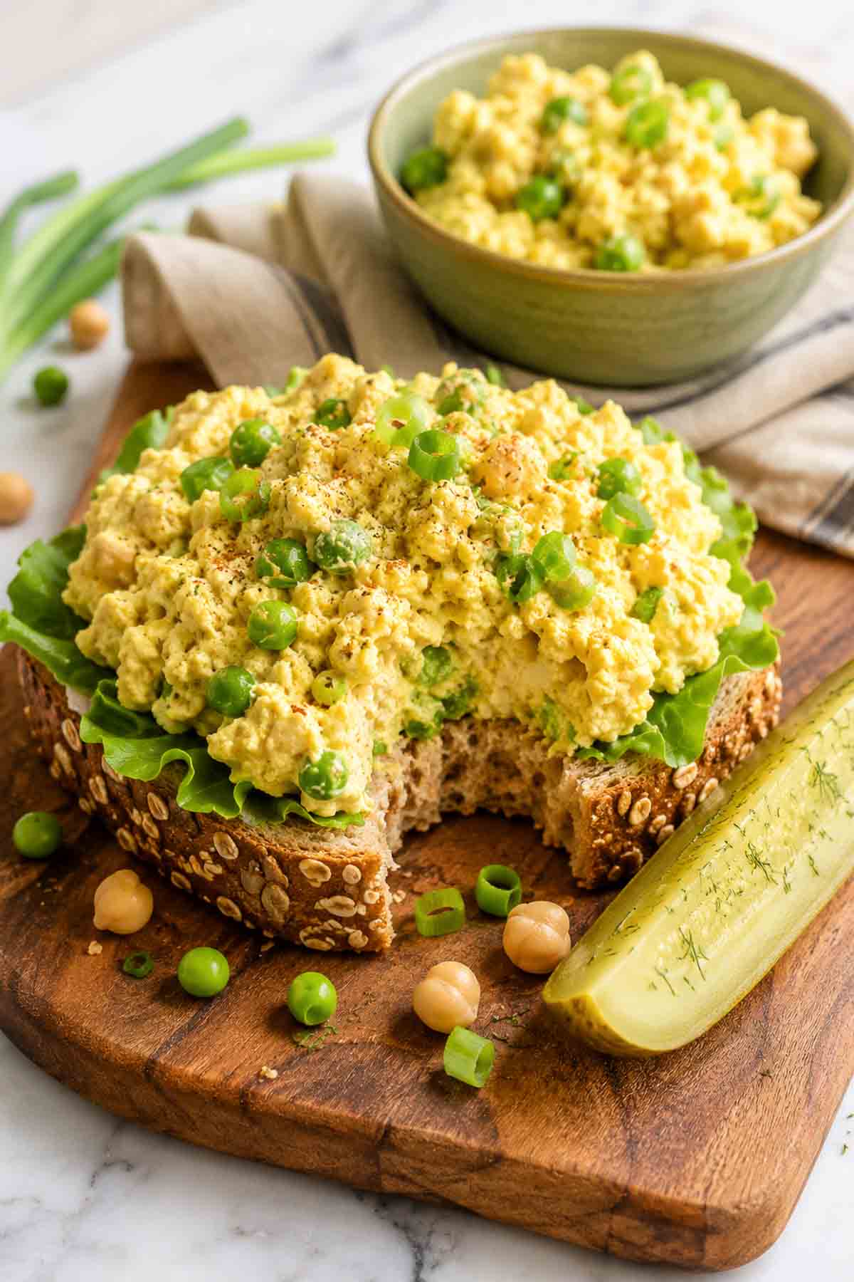 vegan egg salad on an open face sandwich on whole grain bread.