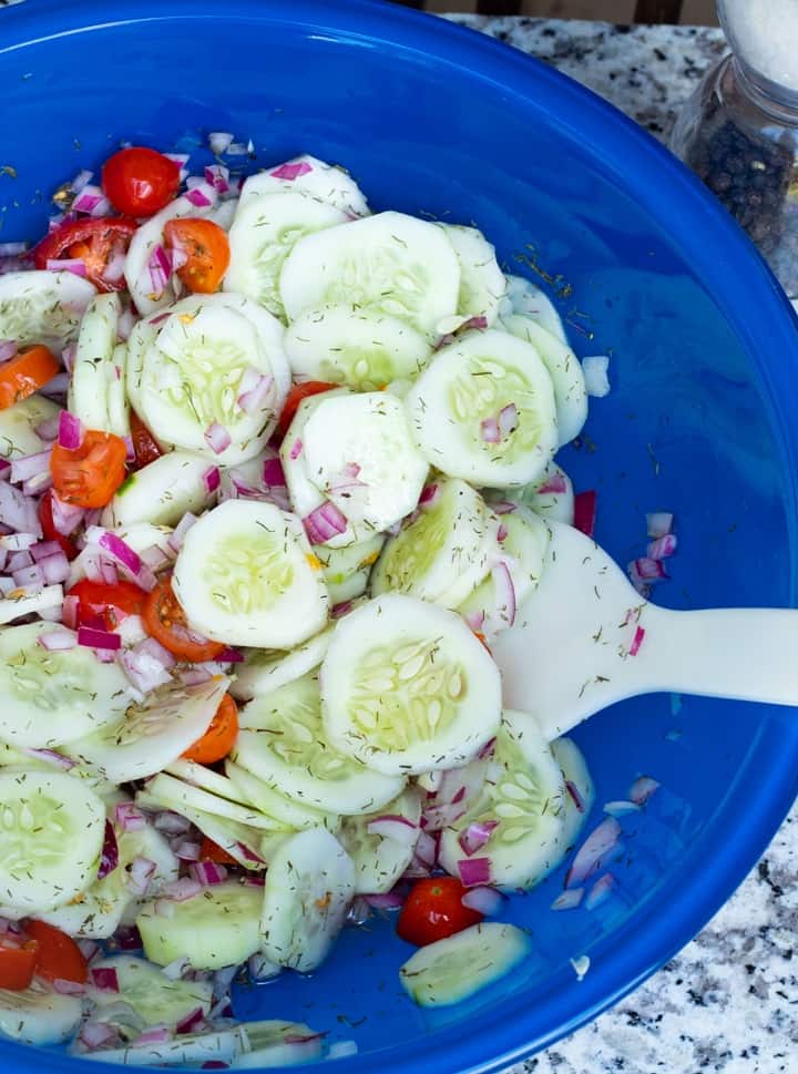 cucumber salad ingredients in large blue bowl