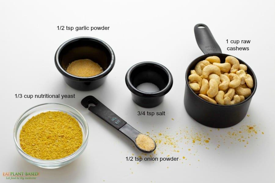 ingredients for vegan cashew parmesan in black bowls on white background