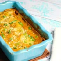 vegan scalloped potatoes in blue casserole dish with antique fork