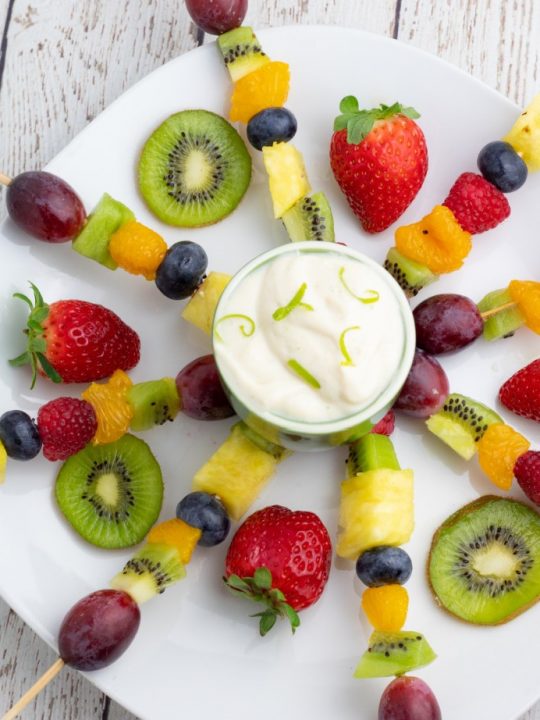 fruit skewers on white plate in a burst position