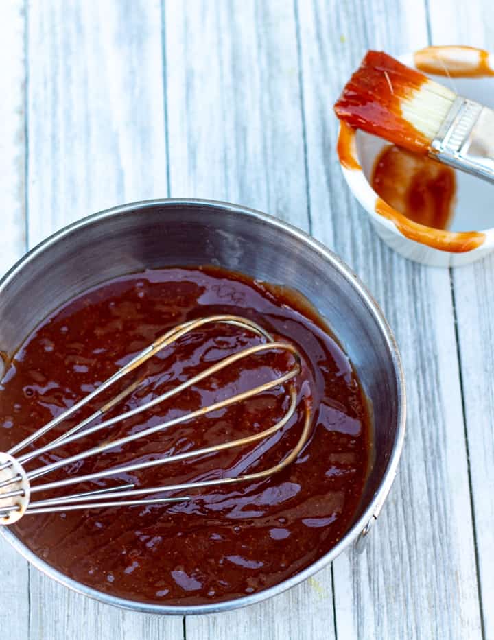 bbq sauce in stainless bowl with whisk