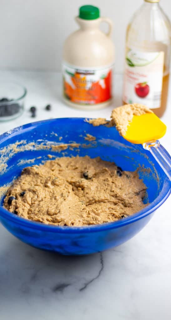 muffin batter in large blue bowl with ingredients in background