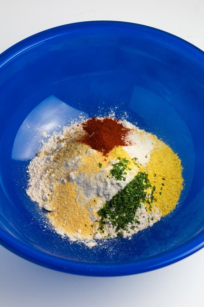 flour and dry seasonings in a large blue bowl