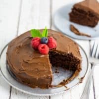 vegan chocolate sugar free cake on silver plate with one slice out