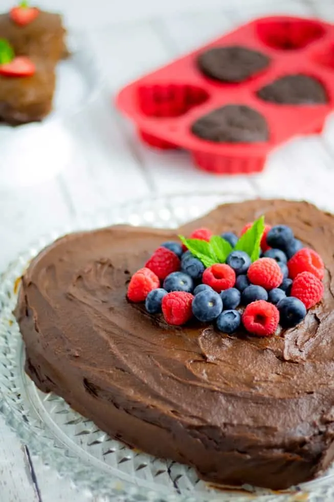 vegan heart shaped chocolate valentine cake topped with berries