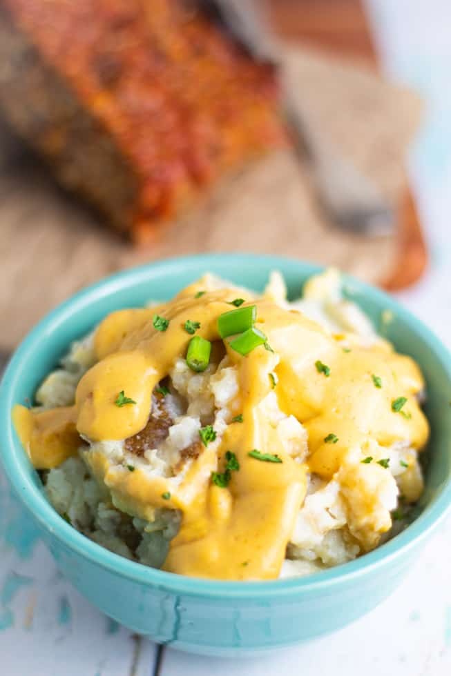 close up of vegan mashed potatoes covered with vegan cheese sauce