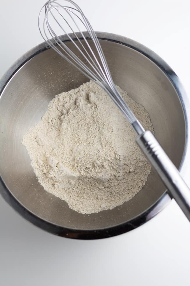 oat flour in stainless steel bowl with whisk