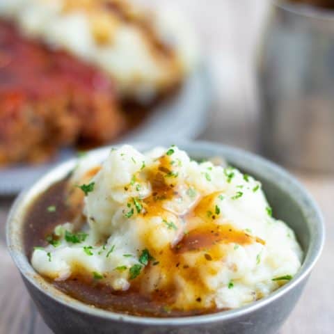 mashed potatoes with gravy in stainless bowl