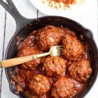 vegan meatballs in cast iron pan with fork on white background
