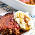 vegan meatloaf on silver plate with mashed potatoes and gravy