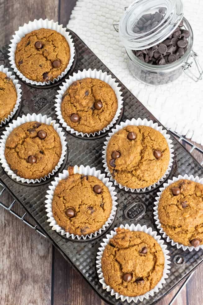 overhead photo of vegan chocolate chip muffins in muffin tin on wooden tabletop