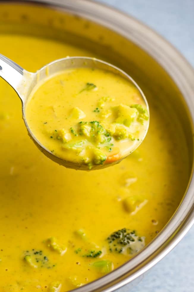 vegan broccoli cheese soup in spoon over pot