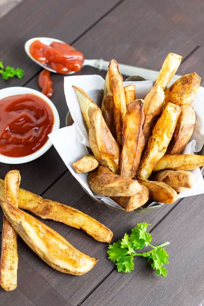 oil free french fries in basket with ketchup on wooden table