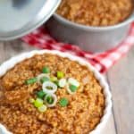 bulgur chili in white bowl with pot of chili in background on wooden table