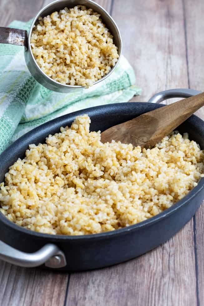 cooked bulgur in pan on wooden table