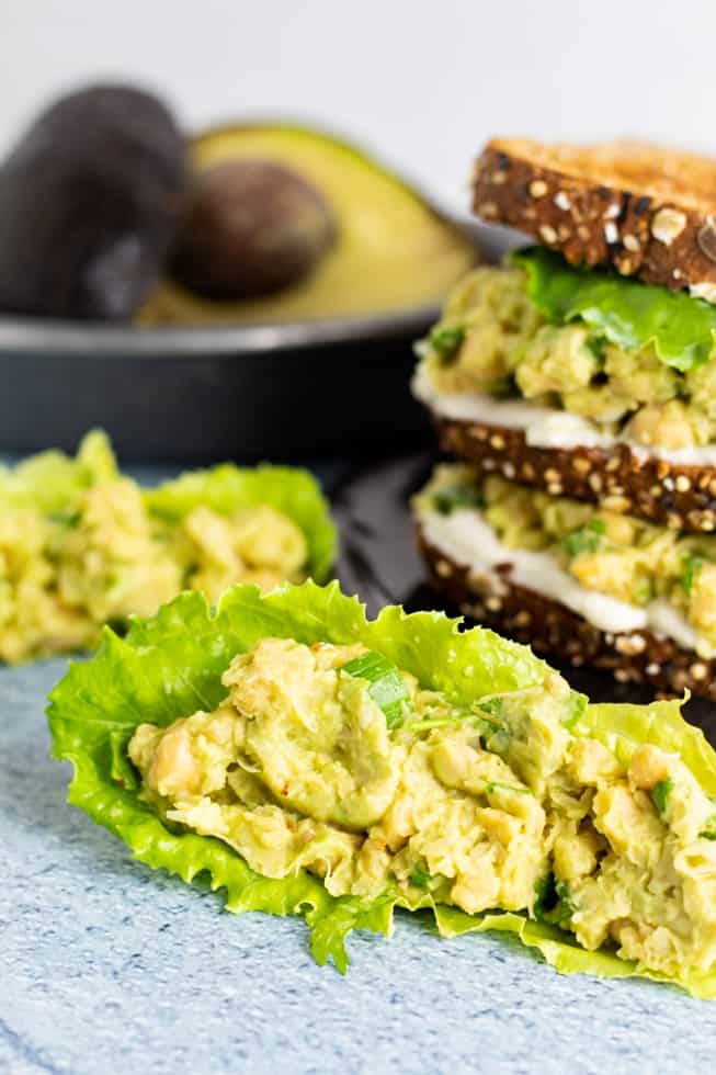 Chickpea salad in lettuce wrap with sandwich in background
