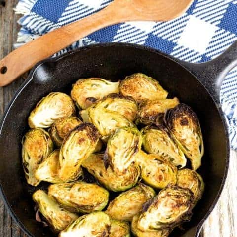 sliced brussels sprouts in cast iron pan on wooden table