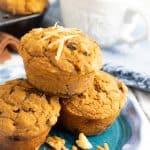 vegan sweet potato muffins stacked on blue plate with coffee in background