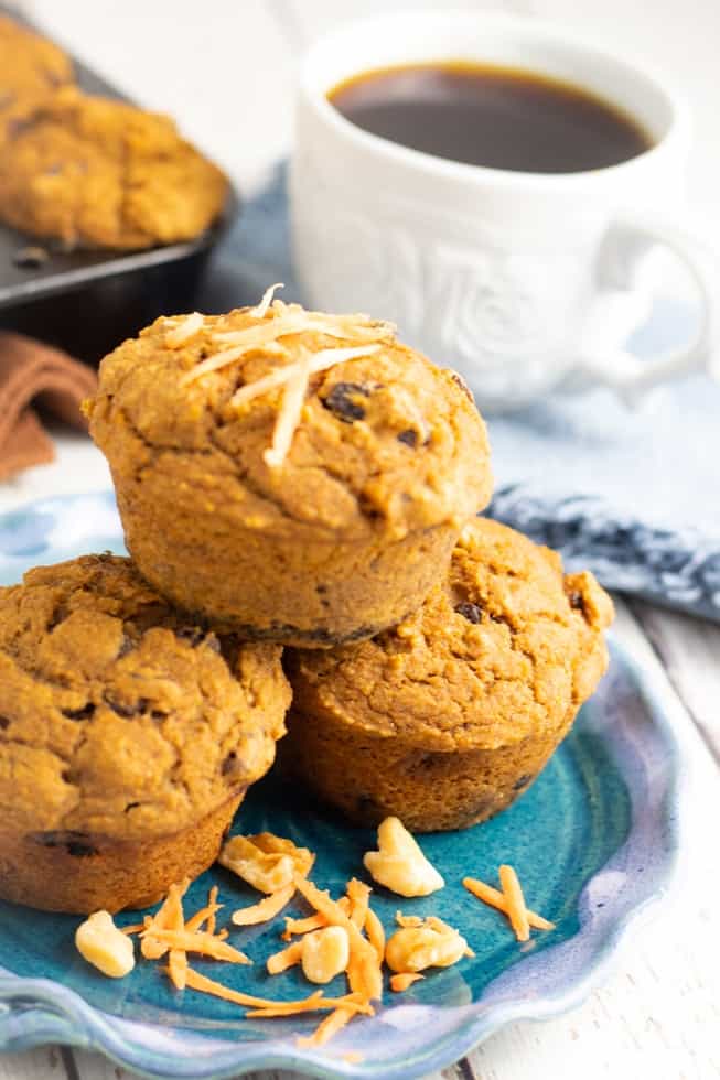 vegan sweet potato muffins stacked on blue plate with coffee in background