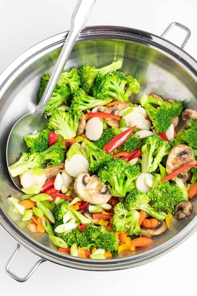 stir fried veggies in stainless wok with spoon