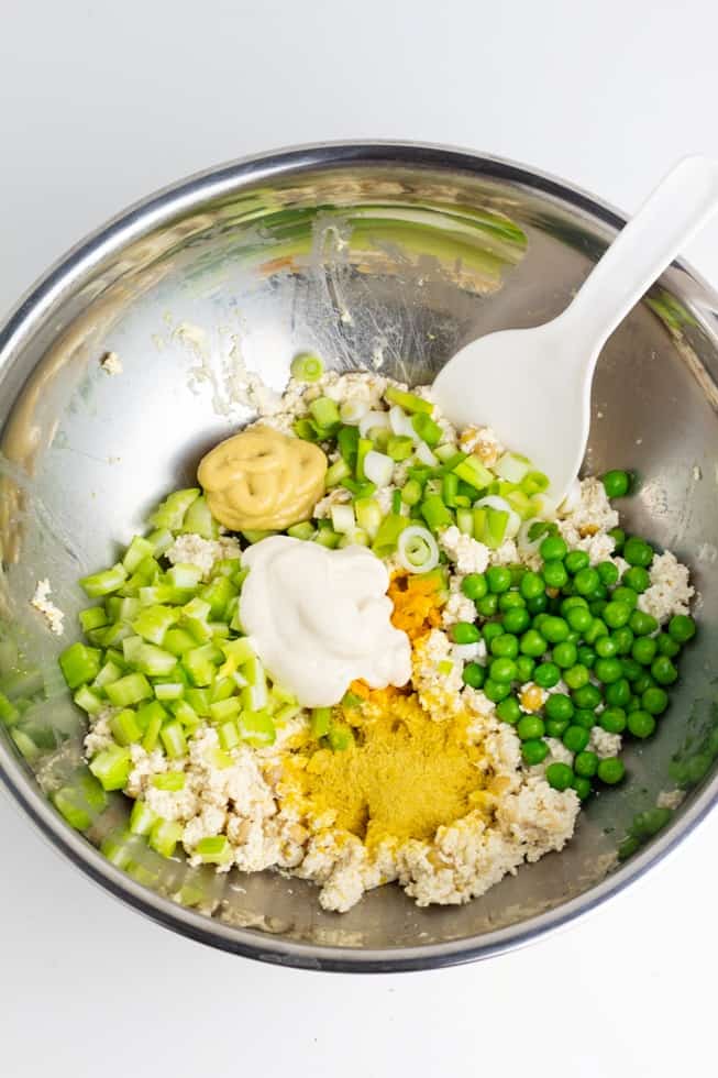 tofu, chickpeas, green peas, green onion, and spices in mixing bowl