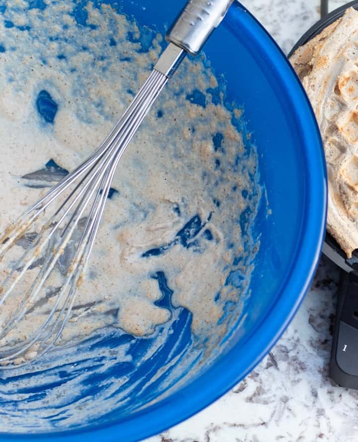 oat flour waffle batter with whisk in blue bowl