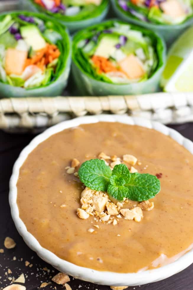 peanut sauce in white bowl with mint and crushed peanuts